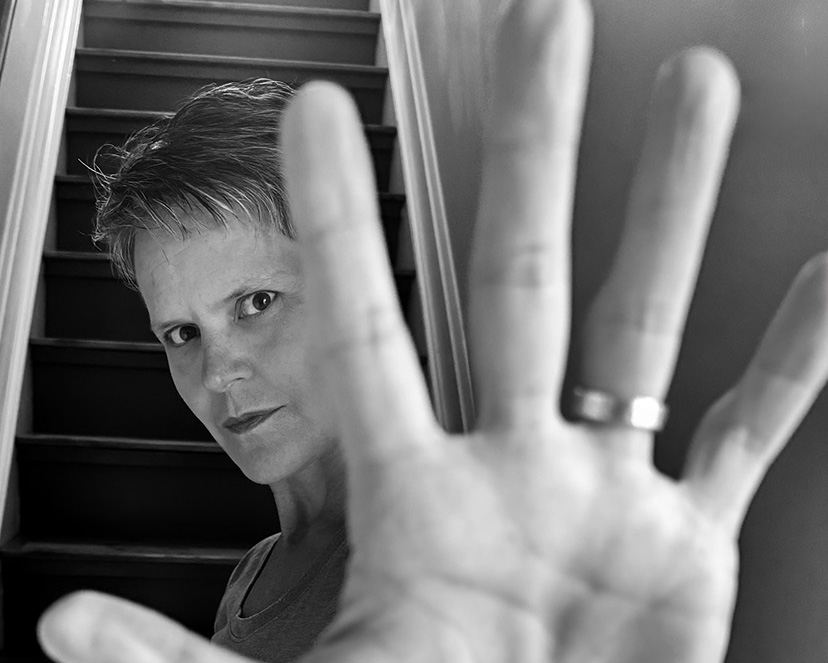 cropped portrait of woman with hand close to lens