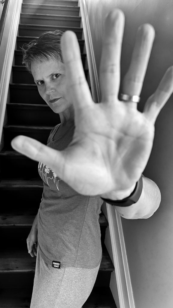 wide angle portrait of woman with hand near camera